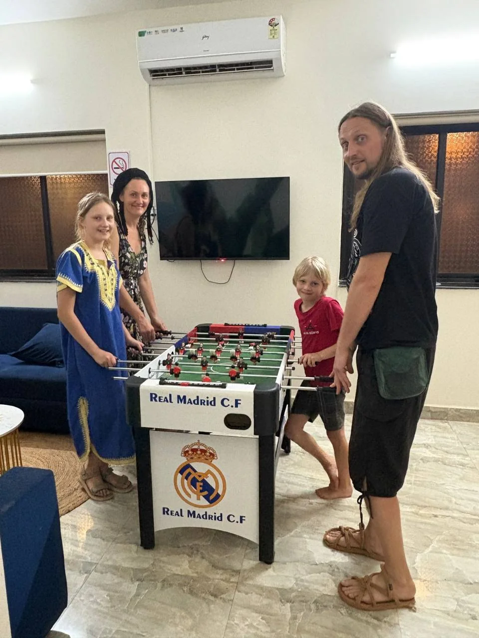 A family playing foosball in the Half Orange game room