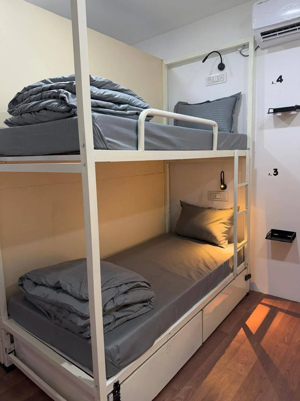 Four-bed dormitory bed with under-bed storage and a reading light at Half Orange