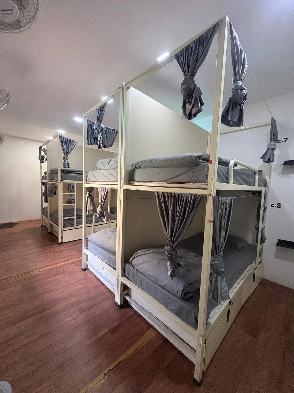 Eight-bed dormitory with privacy curtains and under-bed storage at Half Orange