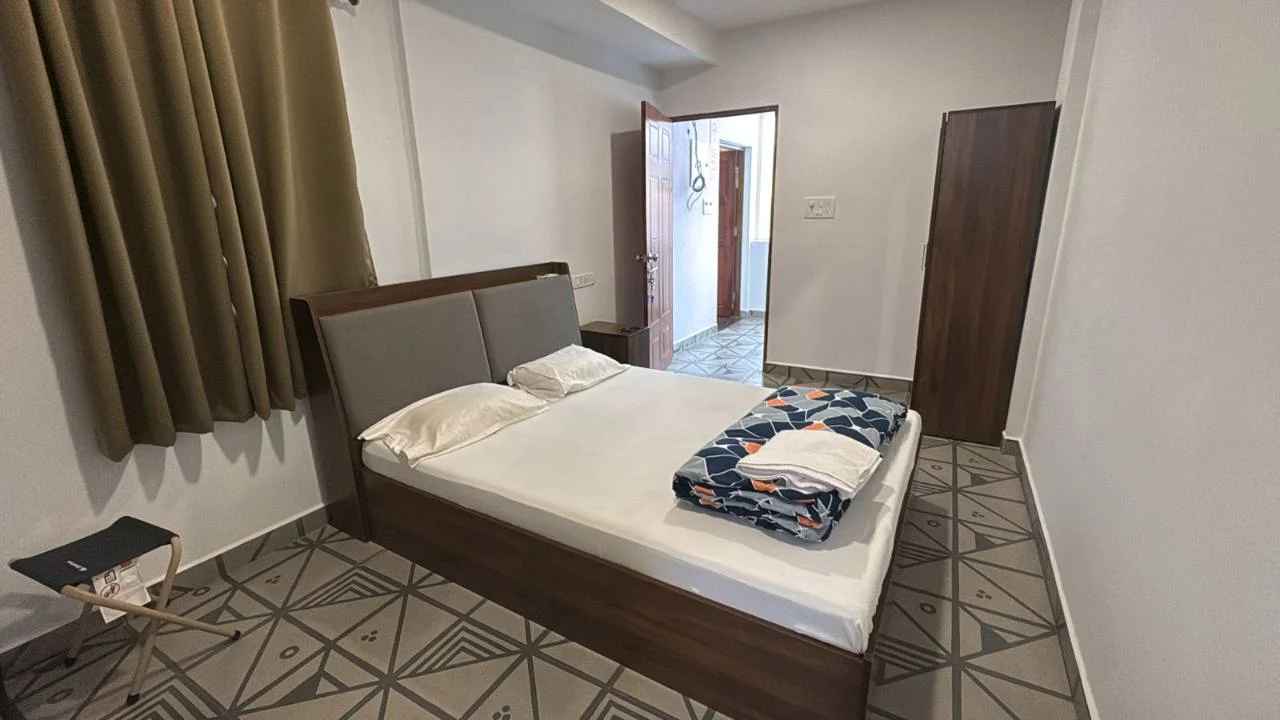 Wide view of the Deluxe Room with a queen-size bed and wardrobe at Half Orange