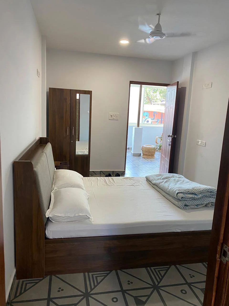 Deluxe Room queen-size bed and wardrobe viewed from the attached bathroom at Half Orange