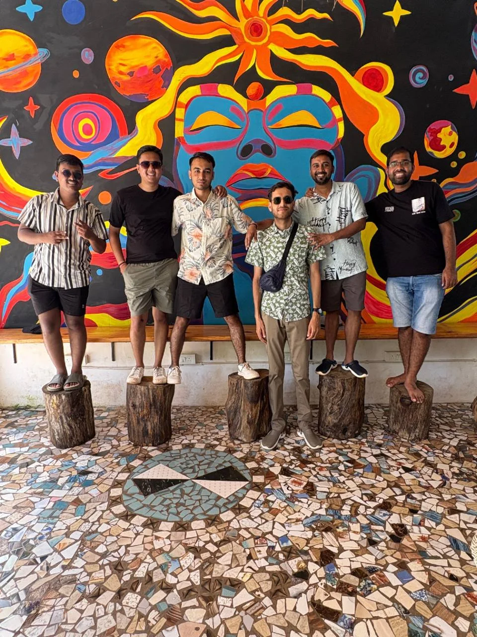 Friends posing in front of the colourful mural at Half Orange